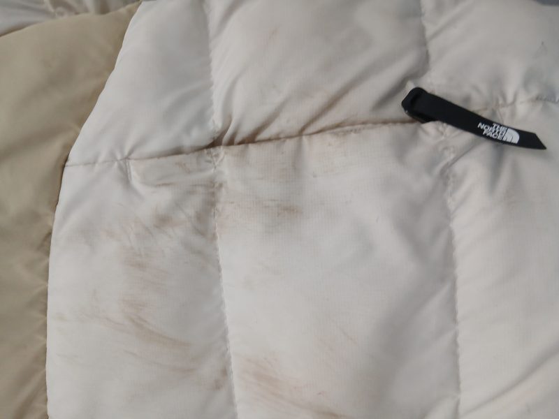 Geacă albă North Face cu pete dificile înainte de curățare profesională eWash
