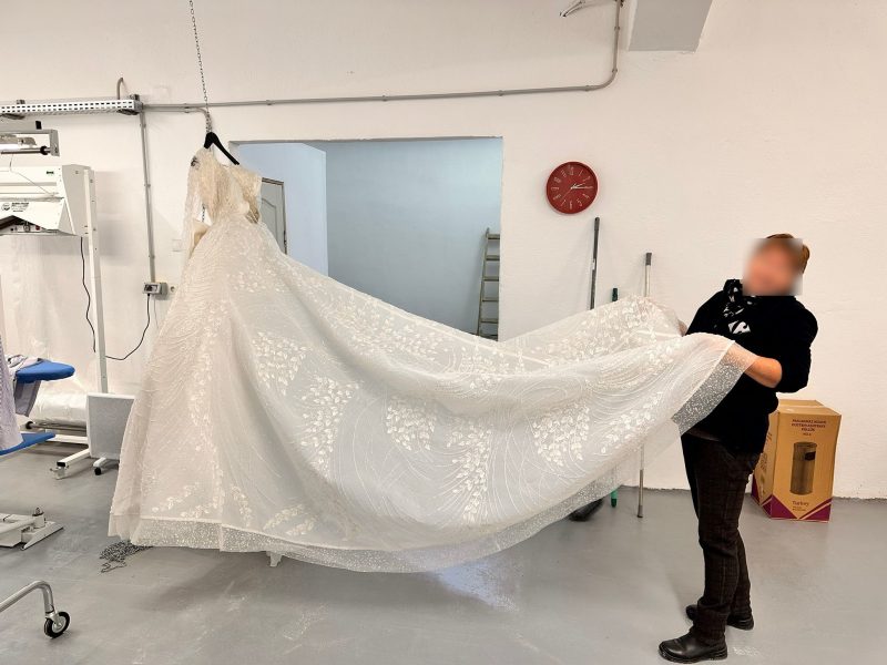 Rochie de mireasă curățată profesional, trena întinsă pentru verificare — eWash Cluj